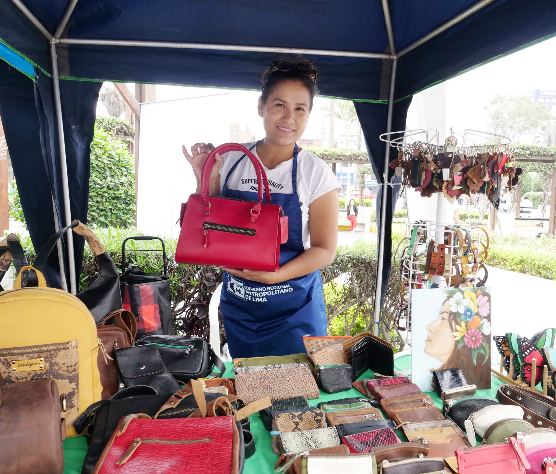 Emprendedora de la Caravana mostrando sus productos de marroquinería en su stand